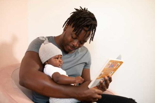 father reading to infant child