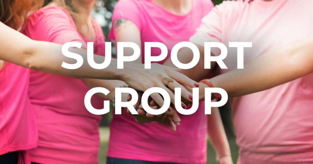 breast cancer support group - ladies with hands extended into middle of group