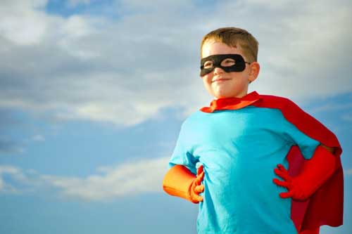 young boy with hero mask and cape