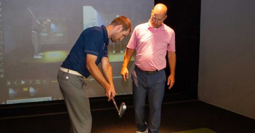 Golf instructor Brian Smith at Hamilton Spine health and sport give a golf lesson in the Full Swing golf simulator