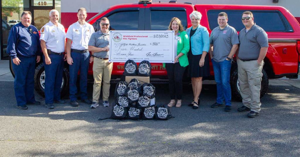 fire department members with a large check